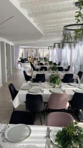 a dining room with white tables and chairs at Casa Budisteanu in Focşani