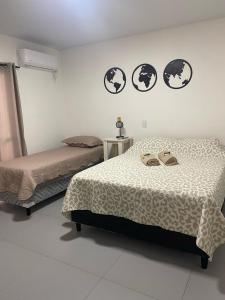 two beds in a white room with two beds sidx sidx sidx at Steves House Flat Hotel in Puerto Iguazú