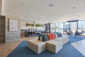 a living room with a white couch and a kitchen at SkyLux Rio Luxo com Garagem in Rio de Janeiro +42 photos