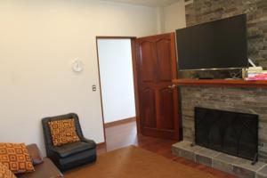 Casa Blanca HaciendaCasa de Campo 15 people with a pool的客厅设有壁炉和平面电视