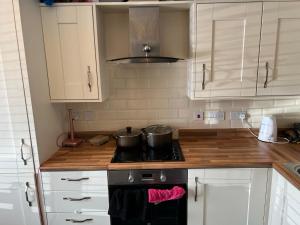 a kitchen with two pots on top of a stove at Butter row in Wolverton +8 photos