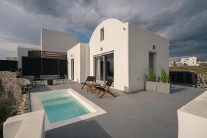 a white house with a swimming pool on a roof at Uranides Luxury Suites in Karterados