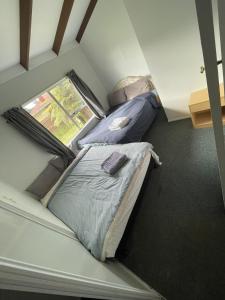 two beds in a small room with a window at 3 Bedroom serviced House A, 9 Steeles Lane in Rotorua +4 photos