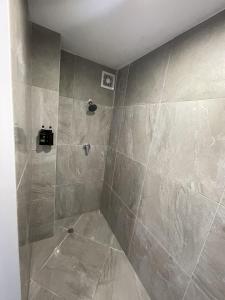 a bathroom with a shower with tiled walls at 3 Bedroom serviced House A, 9 Steeles Lane in Rotorua
