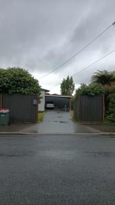 a parking lot with a garage and a fence at 3 Bedroom serviced House A, 9 Steeles Lane in Rotorua