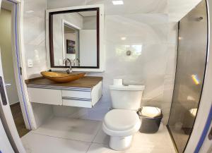 a bathroom with a toilet and a sink and a mirror at Moradas do Campeche CSABC in Florianópolis