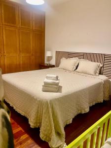 Un dormitorio con una cama grande con toallas. en Casa da Cesta, en Celorico de Basto 8 fotos más