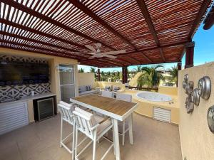 un patio avec une pergola en bois et une table et des chaises dans l'établissement Villa Tostados Acapulco Diamante, à Acapulco
