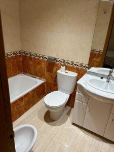 a bathroom with a toilet and a tub and a sink at Apartamento Vacacional Oropesa del Mar primera línea in Oropesa del Mar +9 photos
