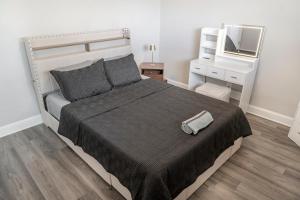a bedroom with a large bed and a mirror at Elegant Home Mins from DTW in Dearborn Heights