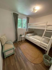 een slaapkamer met 2 stapelbedden en een tapijt bij The Black Bear Cabin in Klamath