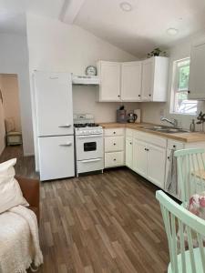 een keuken met witte kasten en een witte koelkast bij The Black Bear Cabin in Klamath +3 foto's