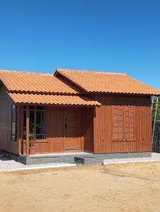 una casa de madera con techo naranja en Casa balneário rincão sc, en Balneário do Rincão