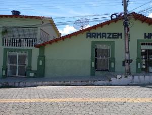 a green and white building next to a street at hospedagem quarto n3casa da Waldir maria in Goiás +3 photos
