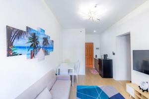 a living room with a white couch and a tv at Tropical 2BR with Pool & Walk to Beach entry to white sand in Lapu Lapu City