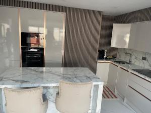 a kitchen with a marble table and two chairs at Cosy 4 bedroom house in borehamwood in Borehamwood +6 photos