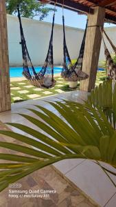 two hammocks on a patio with the ocean in the background at Francisco das Chagas Andrade in Martins
