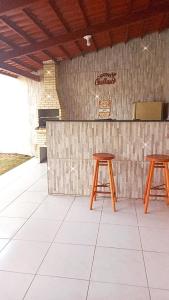 two wooden stools sitting in front of a counter at Francisco das Chagas Andrade in Martins