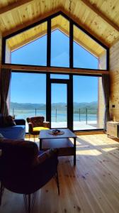 una sala de estar con una gran ventana con vistas al océano en Above the Lake, en Rogani