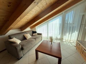 a living room with a couch and a table at Jesolo attic - beach spot in Lido di Jesolo
