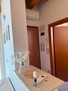 a room with a vase of flowers on a counter at Jesolo attic - beach spot in Lido di Jesolo