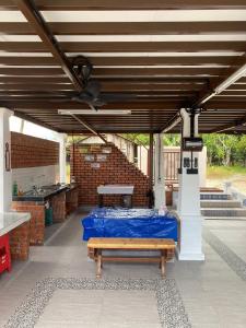 Kampong Bukit NaningにあるGrand Kampung Ayer Hitamの屋根付きのパティオ(テーブル、ベンチ付)