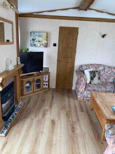 a living room with a couch and a flat screen tv at Lovely 2 bedroomed Caravan on Edwards Towyn in Kinmel Bay
