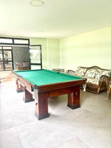 a pool table in a room with a couch at Riviera 200m Praia Serv de Praia and Pisc Aquec in Bertioga