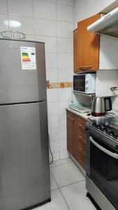 Una cocina con refrigerador de acero inoxidable y estufa. en Departamentos Hometainer, en Santiago 20 fotos más