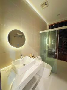 a white bathroom with a sink and a toilet at Mai Linh Hotel in Ðồng Lạc