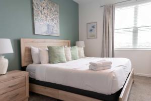 a bedroom with a bed with white sheets and a window at Disney Magic ChampionsGate Resort House 15 min from Disney World, with Club House, 7 Pools and Water Park in Kissimmee