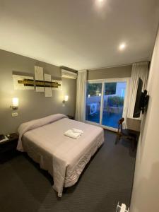 a hotel room with a bed and a window at Hotel Aires de Tandil in Tandil