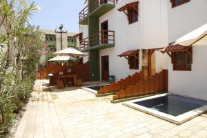 a courtyard of a building with a table and umbrella at Tamandaré Residence Beach 2 in Tamandaré