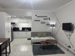 un soggiorno con un divano e un tavolo di Panchitos Nest a Morong