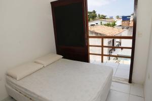 a bedroom with a bed and a window with a view at Tamandaré Residence Beach 2 in Tamandaré