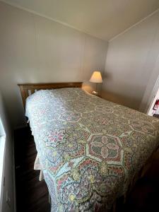 een slaapkamer met een bed met een dekbed erop bij Tall Trees Cabin in a Campground - Plain and Simple in Klamath +4 foto's