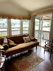 een bruine bank in een woonkamer met balkon bij Tall Trees Cabin in a Campground - Plain and Simple in Klamath