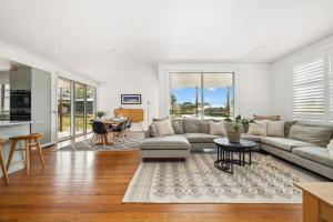 a living room with a couch and a table at Alpine Snow Angels Retreat in Jindabyne