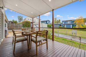 a patio with a table and chairs on a deck at Alpine Snow Angels Retreat in Jindabyne
