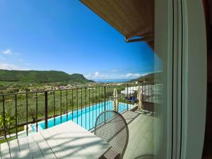 een balkon met uitzicht op een zwembad bij Relais Villa Olivi in Costermano