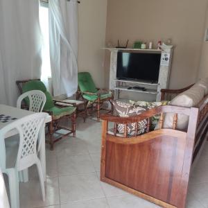 a living room with chairs and a television at Cabo frio Condomínio dos pássaros in Cabo Frio