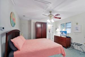 ein Schlafzimmer mit einem Bett und einem Deckenventilator in der Unterkunft Ginger's Guesthouse in Jekyll Island
