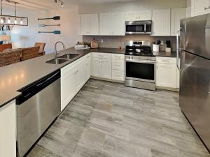 a kitchen with white cabinets and stainless steel appliances at Shore Thang in Port Aransas
