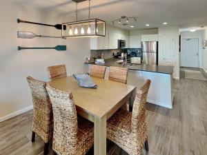 a kitchen and dining room with a wooden table and chairs at Shore Thang in Port Aransas