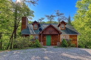 una casa in tronchi con una porta verde su un vialetto di Laurel Cottage, 685 FREE tickets each paid day, Hot Tub, Pool Table! a Sevierville