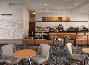 a restaurant with tables and chairs and a counter at JW Marriott Indianapolis in Indianapolis