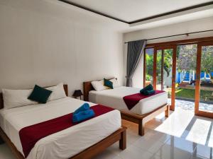 twee bedden in een kamer met een raam bij Secret Point Huts in Nusa Lembongan +37 foto's