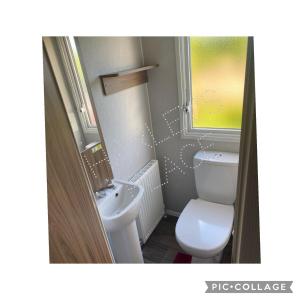 ein kleines Badezimmer mit Toilette und Waschbecken in der Unterkunft 3 bedroomed CH Caravan on Presthaven Beach Resort in Talacre