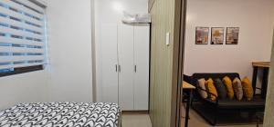 a bedroom with a white cabinet and a chair at Q Workcation WFH Staycation in Manila