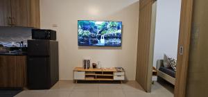 a kitchen with a refrigerator and a tv on the wall at Q Workcation WFH Staycation in Manila